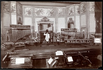 View of the Instrumental Willards, in costume on an elaborate stage filled with unique musical instruments, New York, 1907 by Byron Company